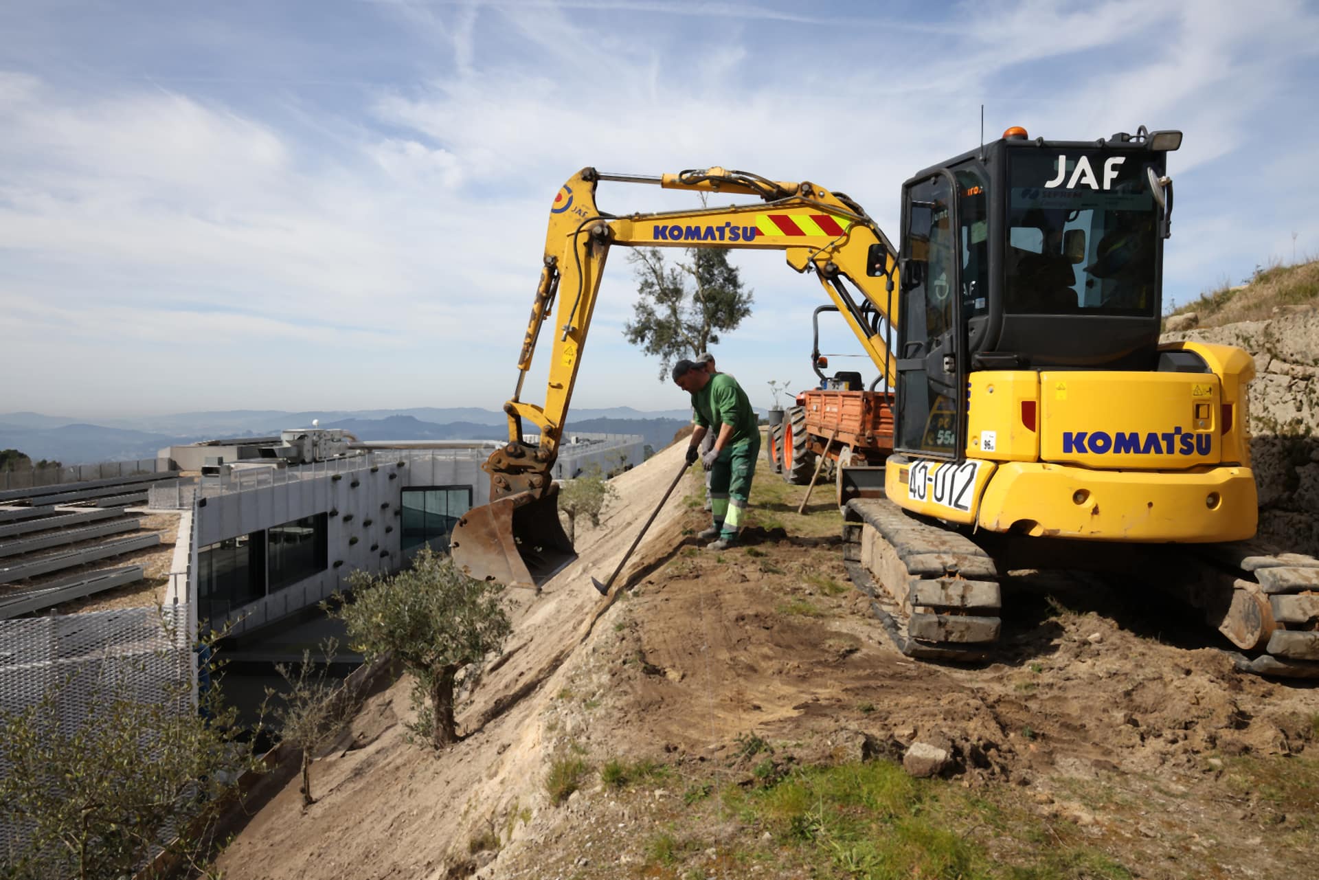 Modelação de terreno e plantação de oliveiras num talude, junto à sede do Grupo JAF